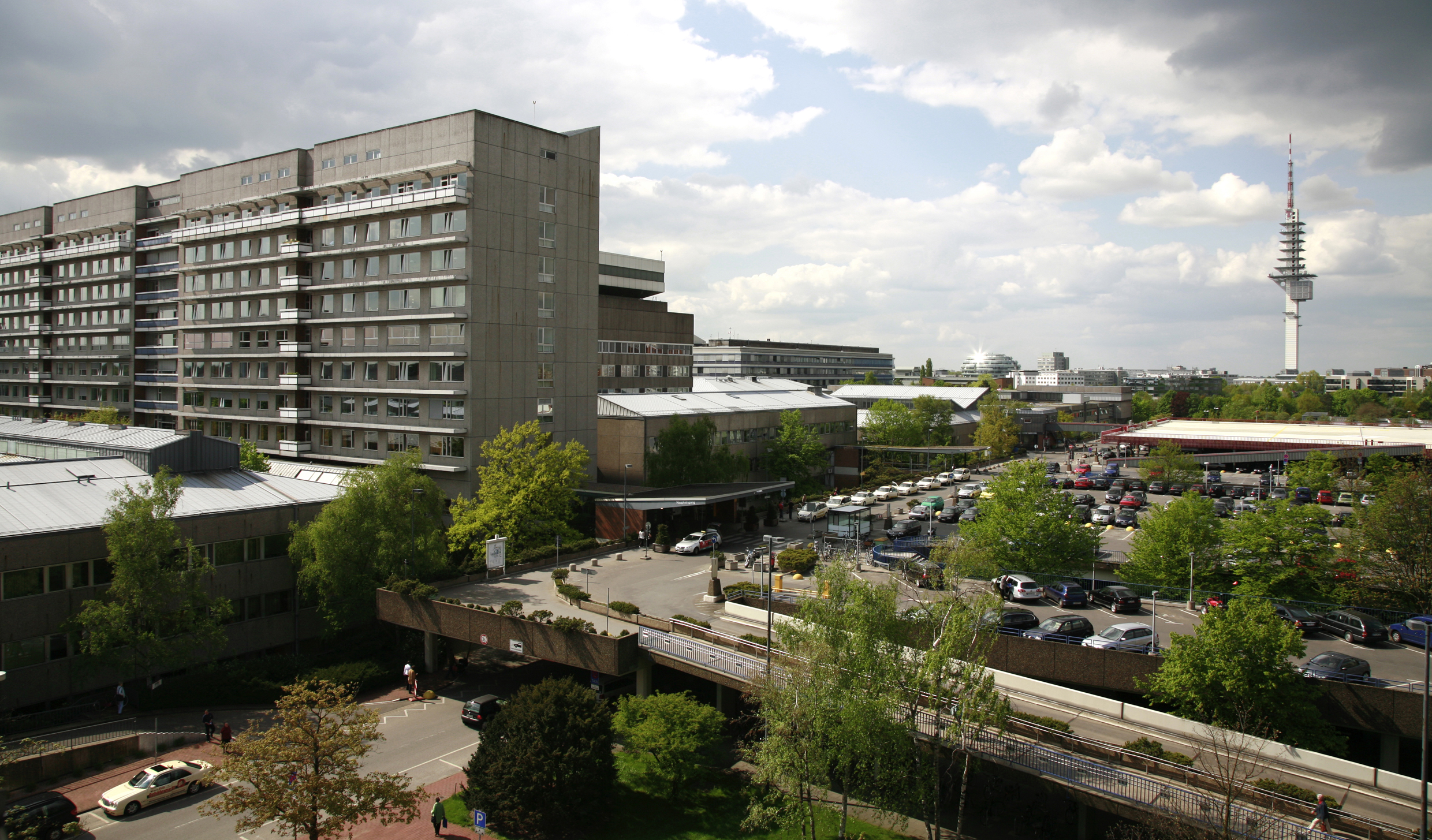 Blick von oben auf das Bettenhaus der MHH mit dem Parkdeck und weiteren Gebäuden des Campus.